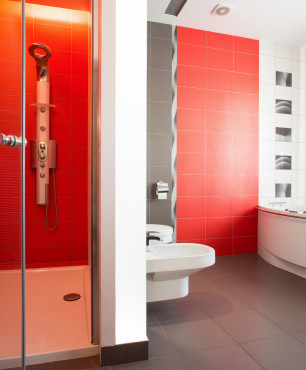 Rotes Badezimmer mit Dusche und Badewanne.