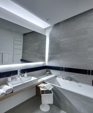 Badezimmer mit grauer Wand und großem Spiegel