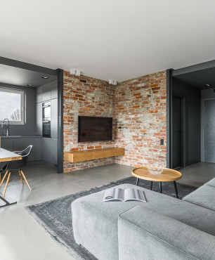 Modernes graues Wohnzimmer mit rotem Backstein