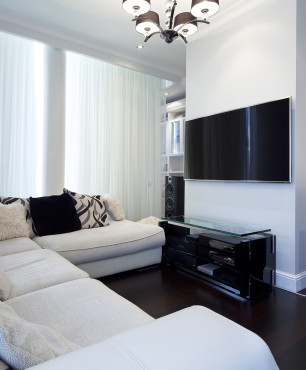 Wohnzimmer mit weißem Ecksofa und TV