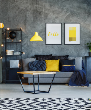 Wohnzimmer mit grauer Wand und gelben Accessoires