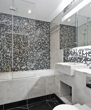 Badezimmer mit Marmorbadewanne und schwarzen und weißen Mosaikfliesen