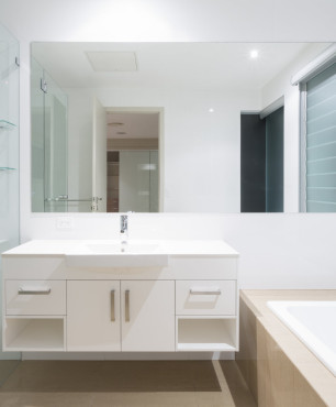 Weißes und graues Badezimmer mit Badewanne und Dusche