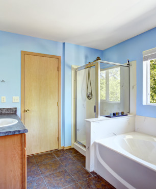 Blaues Badezimmer mit Badewanne und Dusche