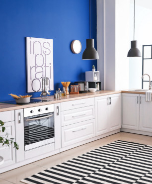 Moderne weiße Küche mit blauer Wand
