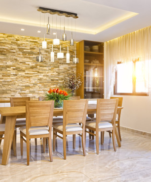 Speisesaal mit Holztisch und Sandsteinwand
