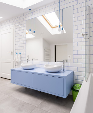 Weißes Loft-Bad mit blauen Schränken.